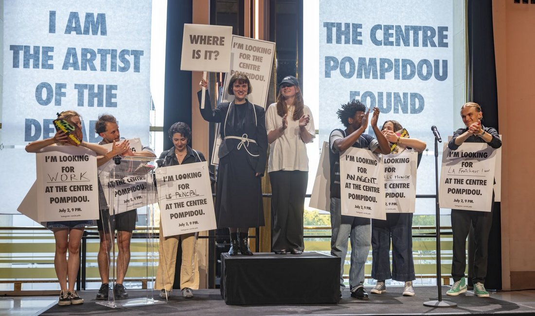 Portrait de groupe : personnes brandissant des panneaux en réponse à la question : qu'est-ce que je viens chercher au Centre Pompidou ?