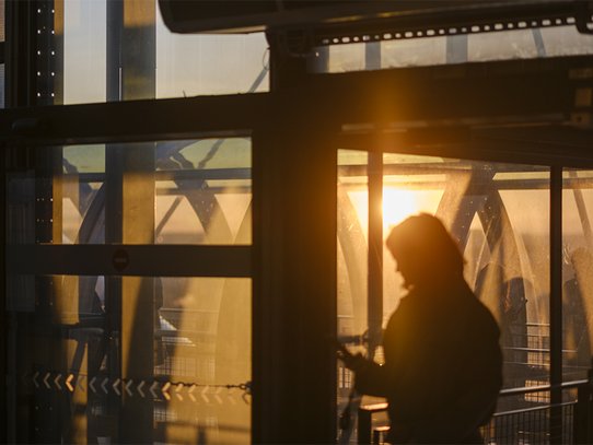 Cette photographie de Pierre Malherbet capture une silhouette féminine traversant les espaces vitrés du Centre Pompidou à Paris dans une lumière chaude de fin de journée. Les structures métalliques emblématiques du bâtiment se mêlent aux reflets dorés du soleil couchant pour créer une composition graphique et immersive. Les transparences, les ombres et les lignes architecturales renforcent l’atmosphère contemporaine et poétique de la scène. La présence humaine, légèrement floue, apporte une sensation de mouvement et de vie au cœur de cette architecture industrielle iconique. L’image évoque à la fois l’énergie culturelle parisienne, la modernité urbaine et une ambiance cinématographique empreinte de calme et de contemplation.